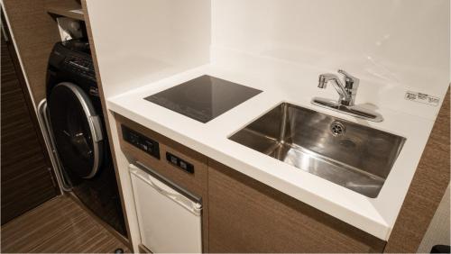 a kitchen with a sink and a washing machine at Via Inn Higashiginza in Tokyo