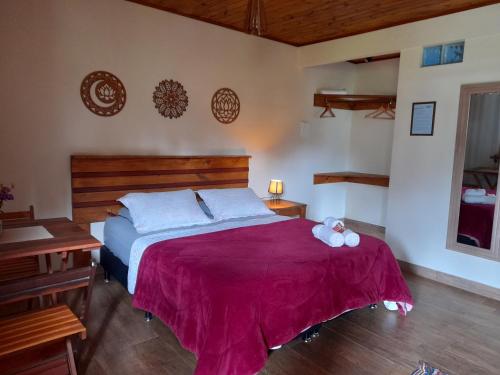 1 dormitorio con 1 cama con manta morada en Pousada Verde & Rio Lumiar, en Lumiar