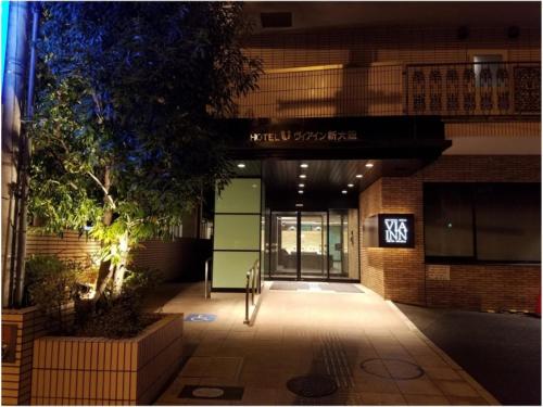 an entrance to a building with a sign on it at Via Inn Shin Osaka in Osaka