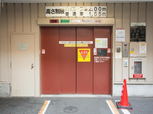 a building with red doors and a sign on it at Via Inn Shin Osaka West in Osaka