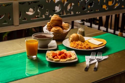 una mesa con dos platos de comida y un vaso de zumo de naranja en HotelSueño Dorado Aguadas, en Aguadas