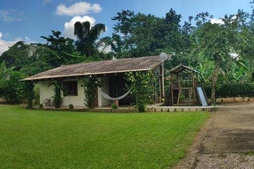 a small house with a hammock in a yard at Recanto do sossego!! in Morretes