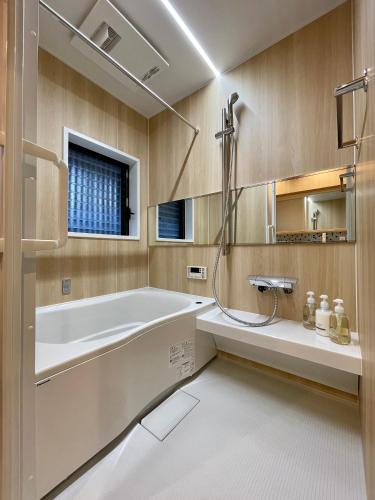 a bathroom with a tub and a shower and a sink at TABITABI KANOE ROKU in Kyoto