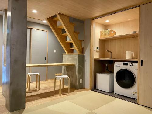 a small kitchen with a washing machine and a staircase at TABITABI KANOE ROKU in Kyoto