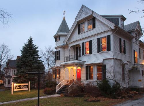 a large white house with a red door at Lang House on Main Street Bed & Breakfast in Burlington