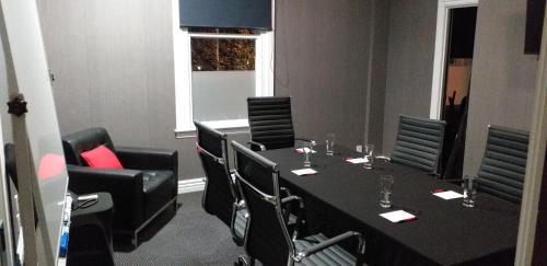 a meeting room with a long table and chairs at Ramada by Wyndham, Hamilton City Center in Hamilton