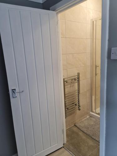 a bathroom with a shower and a white door at Contractor's favourite. Home away from home feel in West Thurrock