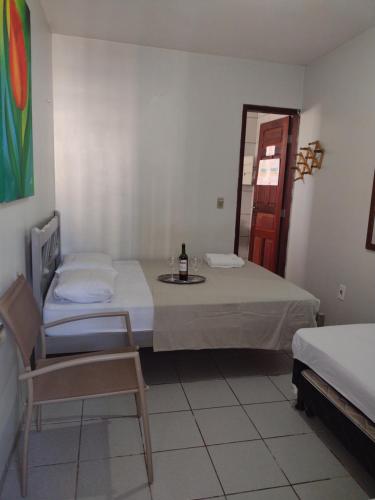 福塔萊薩的住宿－Pousada Centro e Praia，一间设有一张床和一张桌子及一瓶葡萄酒的客房