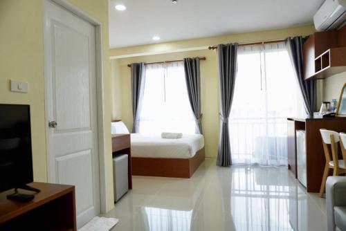 a hotel room with a bed and two windows at The Chiva Sanctuary Khao Yai เดอะ ชีวา แซงค์ทัวรี่ เขาใหญ่ in Pak Chong
