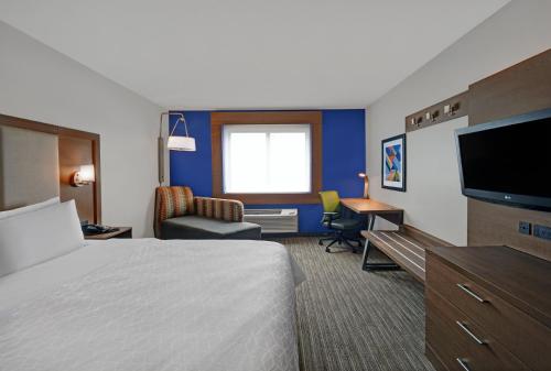 a hotel room with a bed and a flat screen tv at Holiday Inn Express Marshall, an IHG Hotel in Marshall