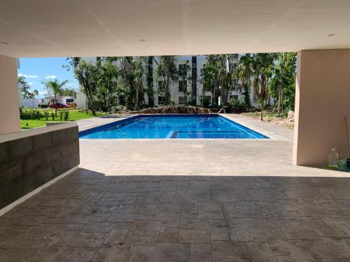 a swimming pool in the middle of a building at Departamento 2 habitaciones vista a la alberca Sky by EITA in Cancún
