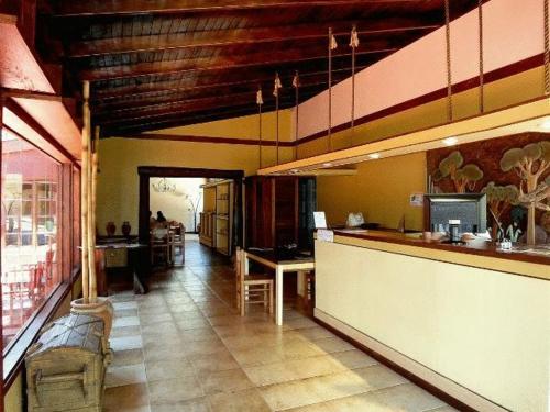 a kitchen with a counter and a dining room at Passaros Suite Hotel in Puerto Iguazú