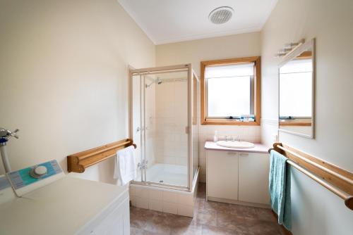 a bathroom with a shower and a sink at Grampians View Cottages and Units in Halls Gap