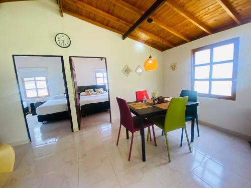une salle à manger avec une table et des chaises ainsi qu'une chambre dans l'établissement SALMA HOTEl, à San Gil