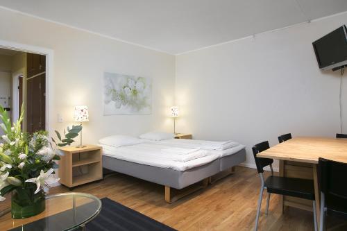 a bedroom with a bed and a dining room with a table at Hotel Copenhagen Apartments in Copenhagen