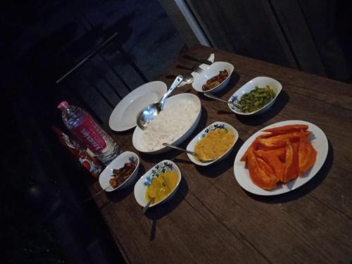 a table with plates of food and bowls of dips at Viyanga Homestay in Ella