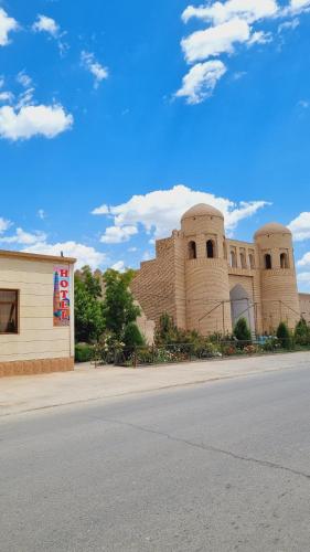 a building with two towers on the side of a street at Khiva Angarik Darvoza in Khiva