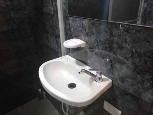 a bathroom with a white sink and a mirror at Habitación Privada Cerca al Aeropuerto y Terminal in Bogotá