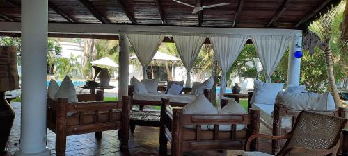 a pavilion with chairs and tables and a table at Kenyan House Malindi in Malindi