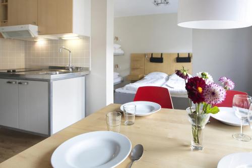 a kitchen with a table with plates and flowers on it at Hotel Copenhagen Apartments in Copenhagen