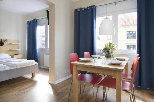 a dining room with a table and chairs and a bed at Hotel Copenhagen Apartments in Copenhagen