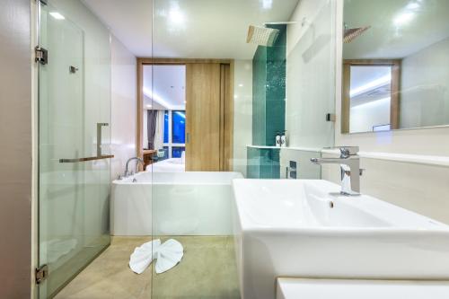 a bathroom with a sink and a tub and a shower at PLAAI Prime Hotel Rayong SHA Extra Plus in Rayong