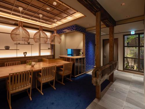 a dining room with a large wooden table and chairs at THE MACHIYA KAZAHAYA in Kyoto