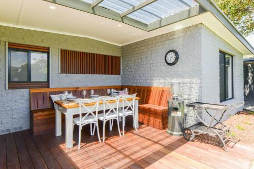 a patio with a table and chairs on a deck at Foam St Serenity in Rosebud