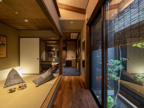 a living room with a couch and a large window at THE MACHIYA KAZAHAYA in Kyoto