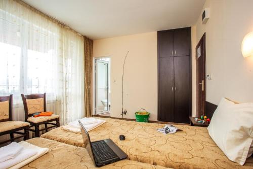 a room with a bed with a laptop on it at Family Hotel Saint Konstantin in Glavatartsi