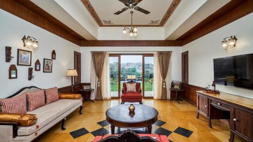 Una sala de estar con un sofá y un televisor. en Grape County Eco Resort & Spa, Nashik, en Nashik