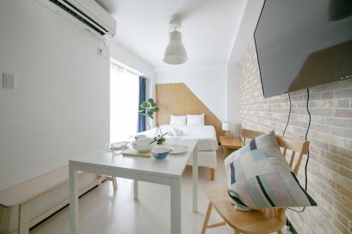 a living room with a table and a bed and a room at Green Sea Oshiage in Tokyo