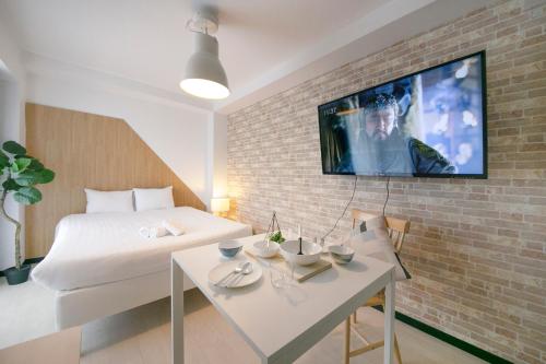 a room with a bed and a tv on a brick wall at Green Sea Oshiage in Tokyo