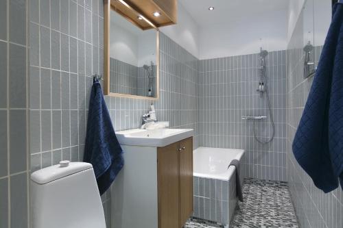 a bathroom with a sink and a toilet and a mirror at Hotel Copenhagen Apartments in Copenhagen