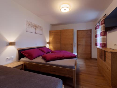 a bedroom with a large bed with red pillows at Urlaub am Obsthof Pieber in Weiz