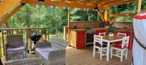 une véranda avec une cuisine et une table dans l'établissement Yourte indépendante en pleine nature, proche d'Ajaccio, à Carbuccia