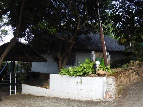 a small white house with a staircase in front of it at Impala Niezel Lodge & Guest House in Hazyview
