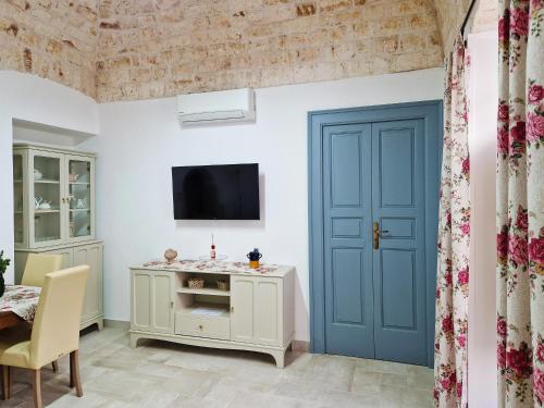 a living room with a blue door and a tv at Dimora Biancodoro in Locorotondo
