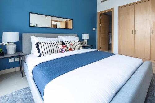 a bedroom with a large bed with a blue wall at Frank Porter - Park Island Fairfield in Dubai