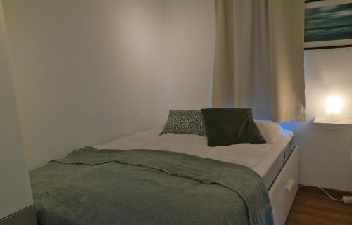 uma cama num quarto com um cobertor verde em Strandgeluk, Joost de Moorstraat 6 em Cadzand