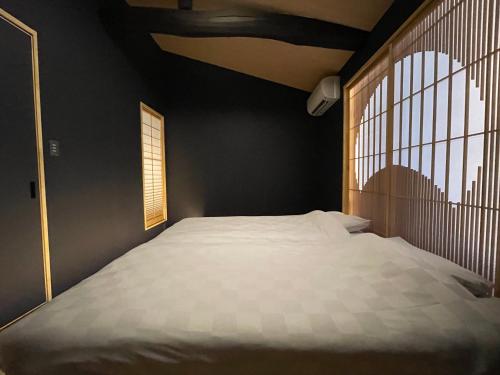 a bedroom with a large bed with a window at TABITABI KANOE HARA in Kyoto