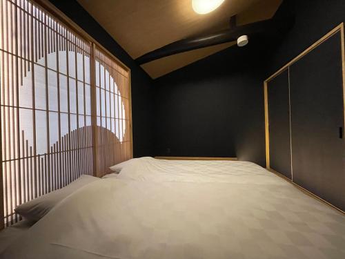 a bed in a room with a window at TABITABI KANOE HARA in Kyoto