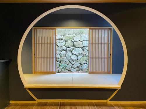 an arched window in a room with a stone wall at TABITABI KANOE HARA in Kyoto