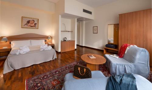 Habitación de hotel con cama, mesa y sillas en Hotel Il Duca d'Este, en Ferrara
