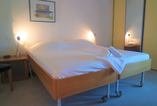 łóżko z białą pościelą i dwoma ręcznikami w obiekcie Seaview, Deurloo 53-12 Cadzand w mieście Cadzand