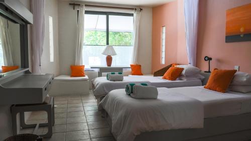 a room with three beds and a window at Flamboyant Diani Beach in Diani Beach