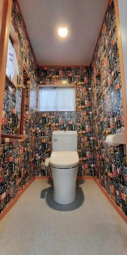 a bathroom with a toilet and a wall covered in photos at 一棟丸ごと・YOURSとなり in Osaka