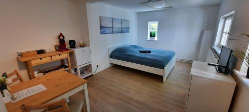 グレーミッツにあるPuken Apartmentのベッドとデスクが備わる小さな客室です。
