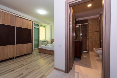 Un baño grande con una cama y un inodoro. en C&Y Marco Apartments, en Mamaia