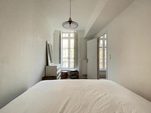 una camera bianca con un grande letto bianco di Le petit Cordelier a Dinan